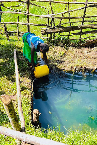 A community member fills a container at one of the new fresh water springs in Nandi County, Kenya. Eva Tokoi/International Crane Foundation