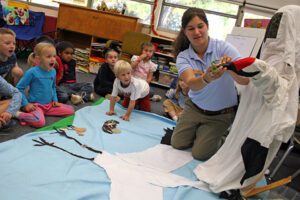 An International Crane Foundation educator shares the Whooping Crane costume and puppet with a classroom.